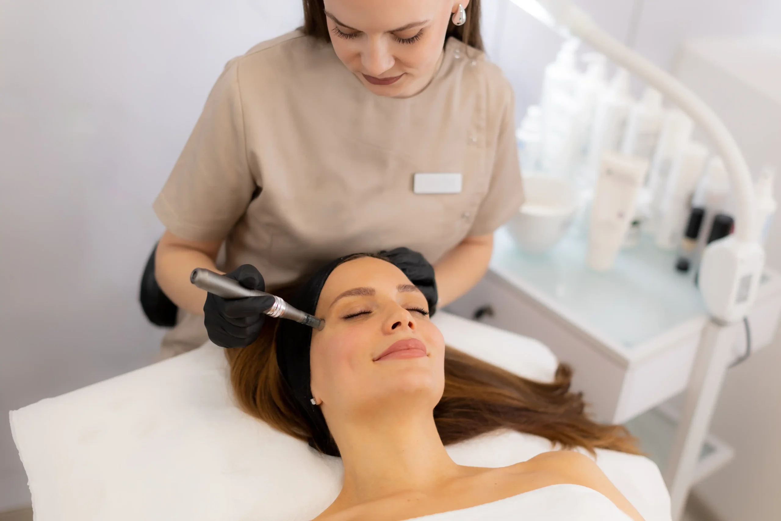 Esthetician performing microneedling treatment on a relaxed woman to improve skin texture and radiance at a modern medspa