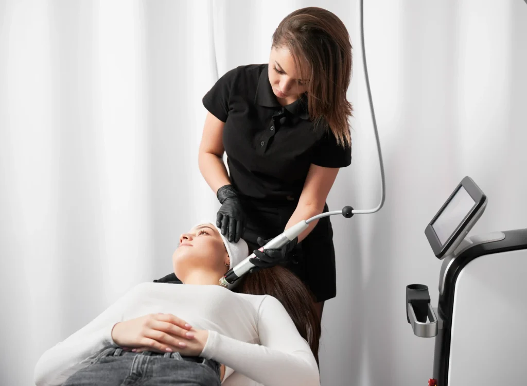 Aesthetic specialist performing QuantumRF facial treatment on a relaxed patient at Essential Aesthetics & Health in Fort Lauderdale, FL.